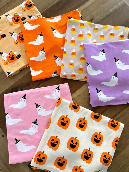 Colorful Halloween-themed fabric squares featuring ghosts, pumpkins, and candy corn in various designs.