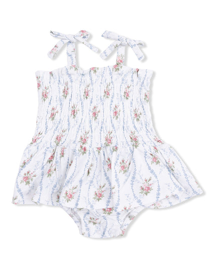 Floral-patterned baby romper with smocked bodice and tie straps, featuring a flared skirt design.