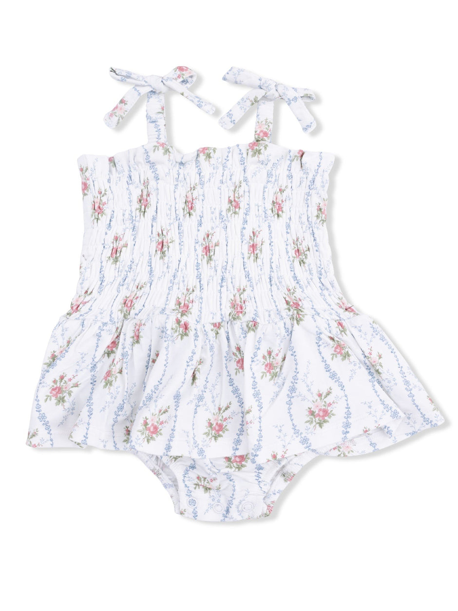 Floral-patterned baby romper with smocked bodice and tie straps, featuring a flared skirt design.