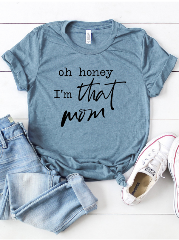 Blue t-shirt with the text "oh honey I’m that mom," paired with jeans and white sneakers.