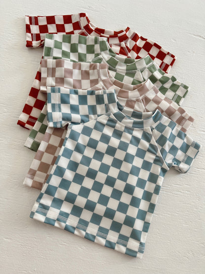 Colorful checkered shirts in red, green, blue, and brown arranged neatly on a light background.