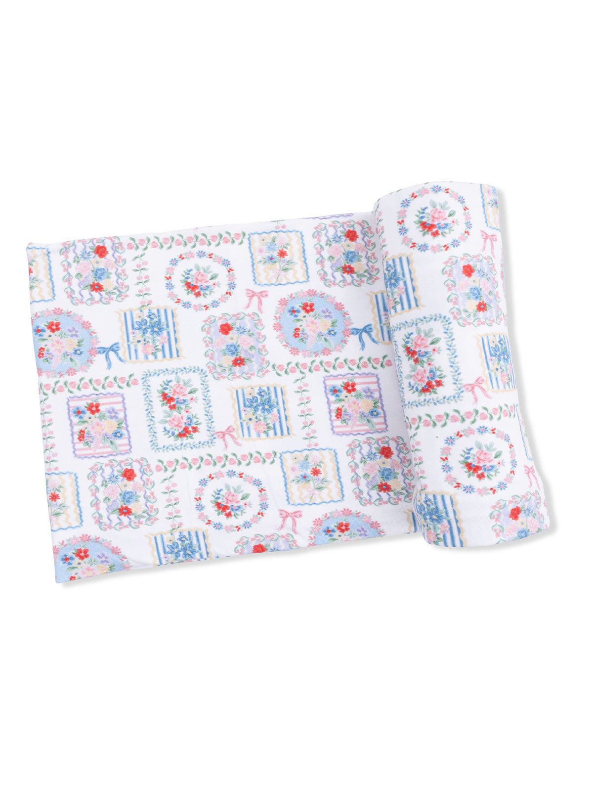 Colorful floral patterned fabric rolled up, featuring pastel hues and decorative motifs.