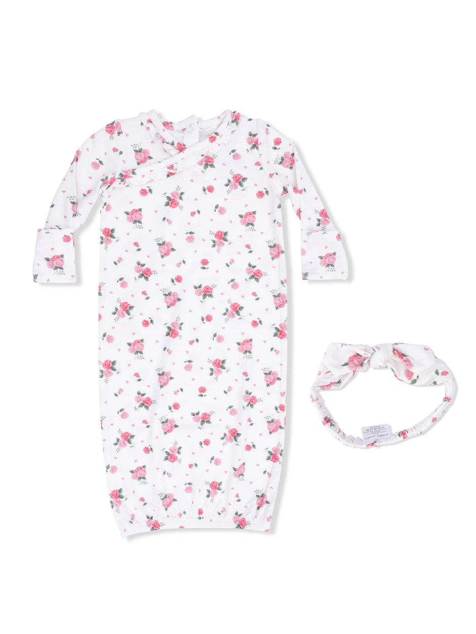 White floral newborn gown with pink roses and matching headband on a light background.