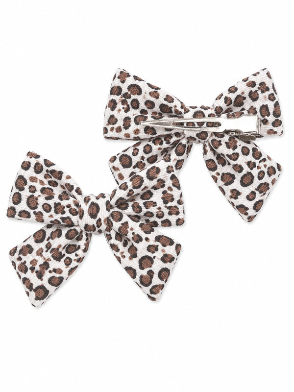 Pair of leopard print hair bows in white and brown, one with a clip and one without.