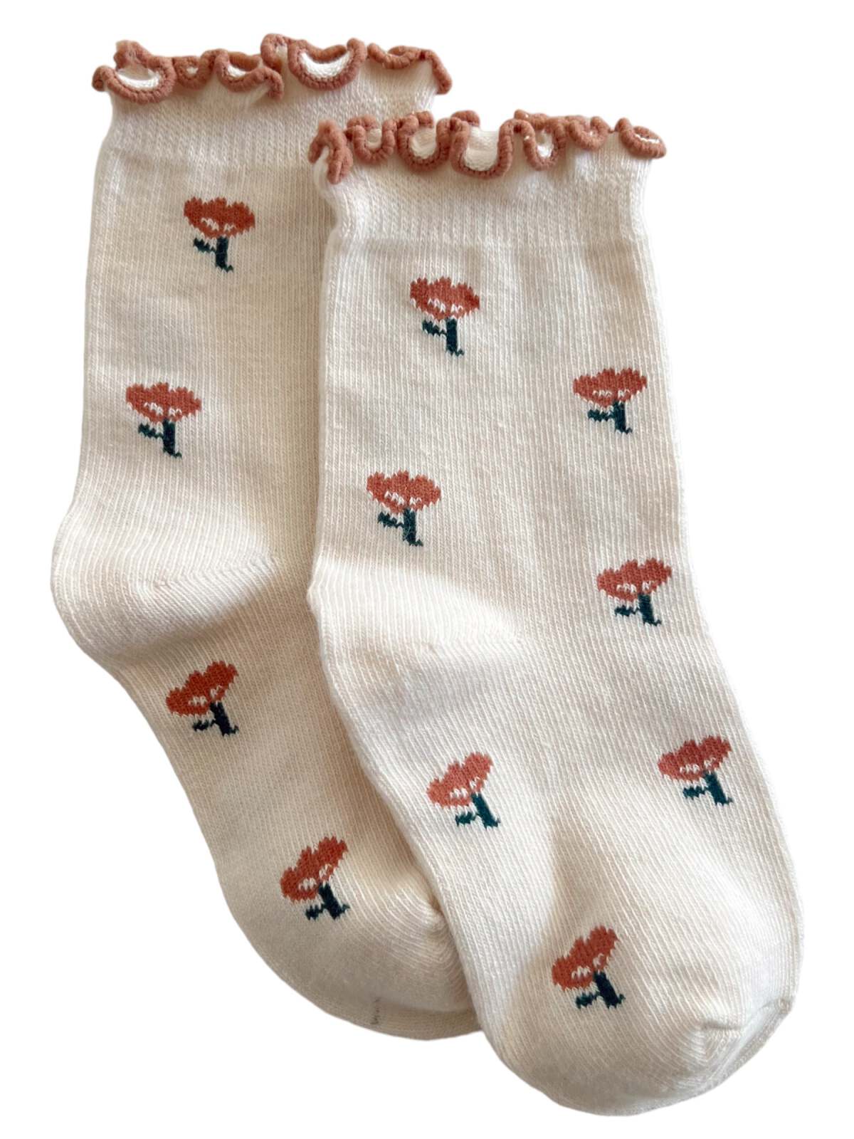 Cream-colored socks with a ruffled edge and small floral patterns. Suitable for casual wear or cozy indoor use.