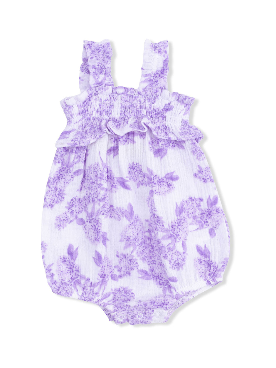 Lilac floral baby romper with ruffled straps and snap closure. Perfect for warm weather occasions.