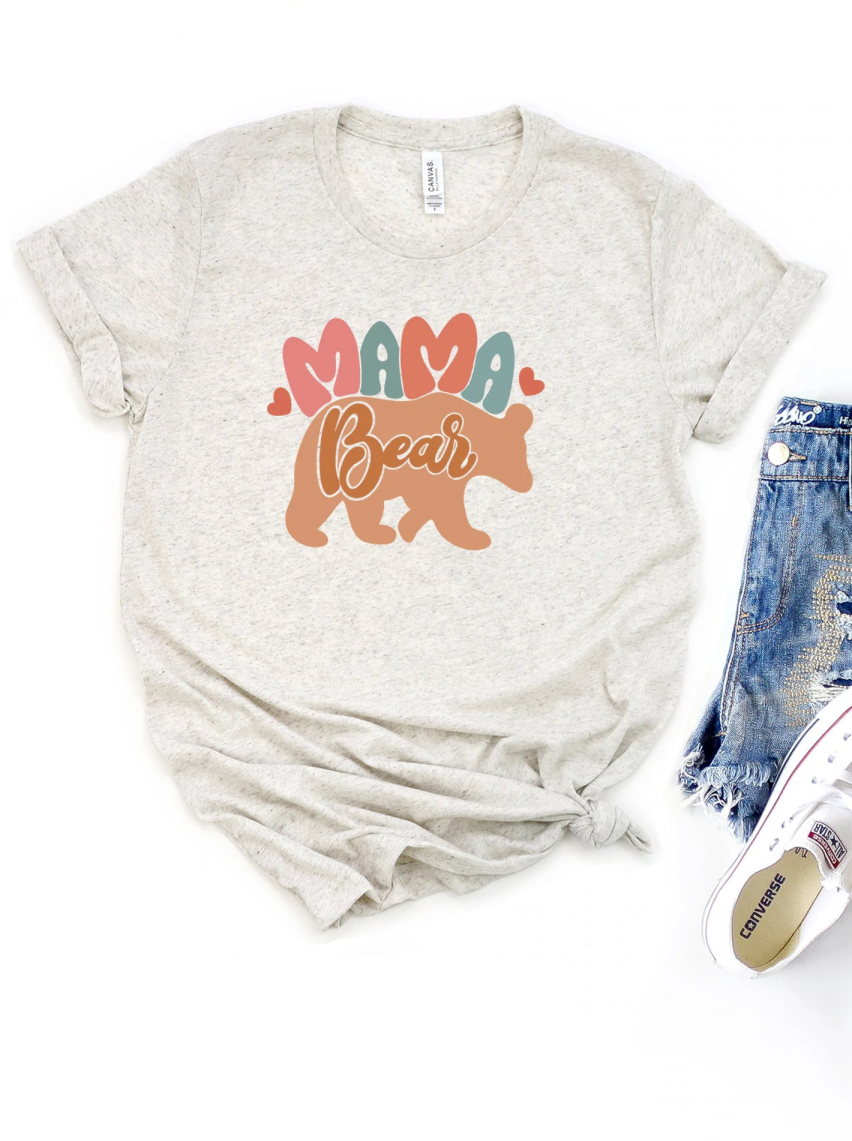 Gray t-shirt with "Mama Bear" graphic and hearts, paired with distressed denim shorts and white sneakers.