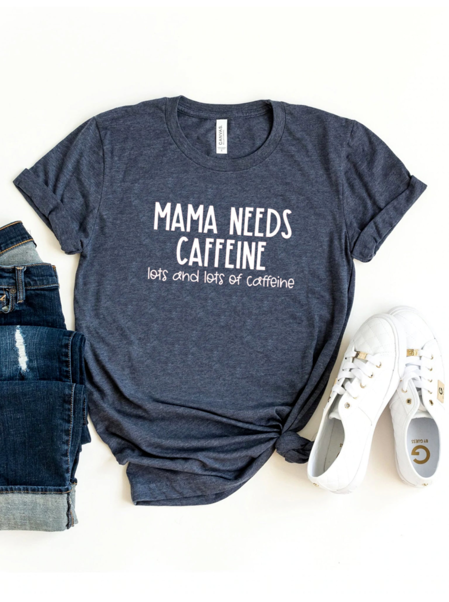 Navy blue t-shirt with "Mama Needs Caffeine" text, styled with denim jeans and white sneakers.