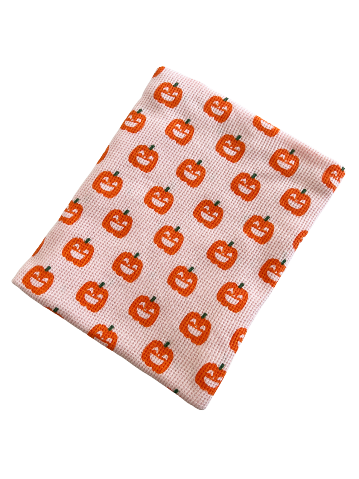 Pink cloth with a repeating pattern of smiling orange pumpkins. Ideal for Halloween decor or themed events.