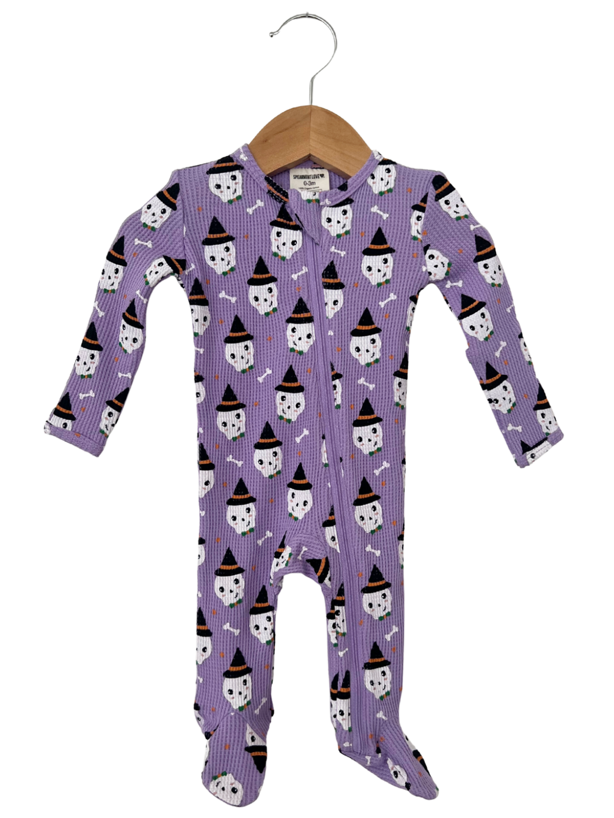 Purple infant onesie with ghost and Halloween hat patterns, hanging on a wooden hanger.