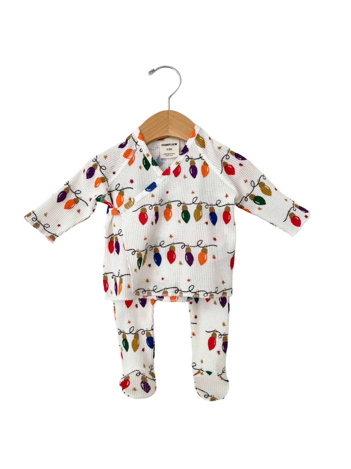 Holiday-themed baby outfit featuring colorful string lights on a white background, displayed on a wooden hanger.