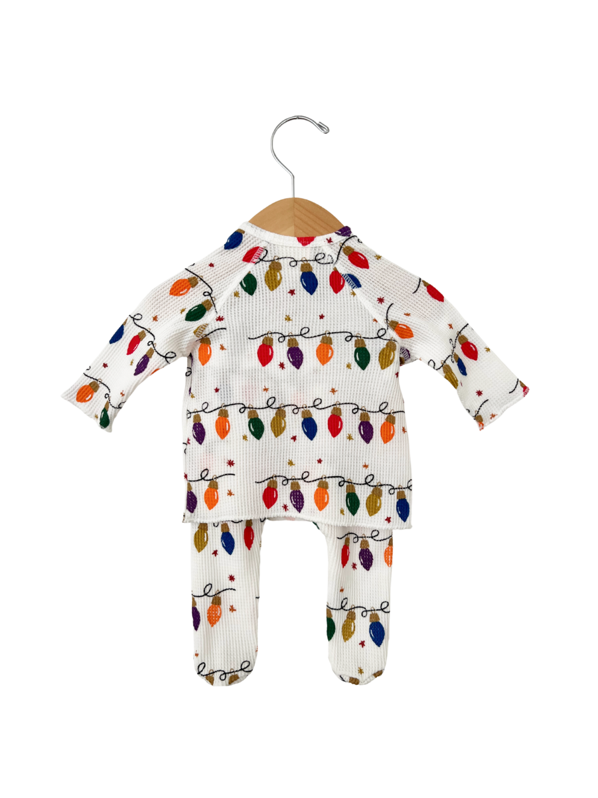 White children's outfit with colorful holiday lights, hanging on a wooden hanger.