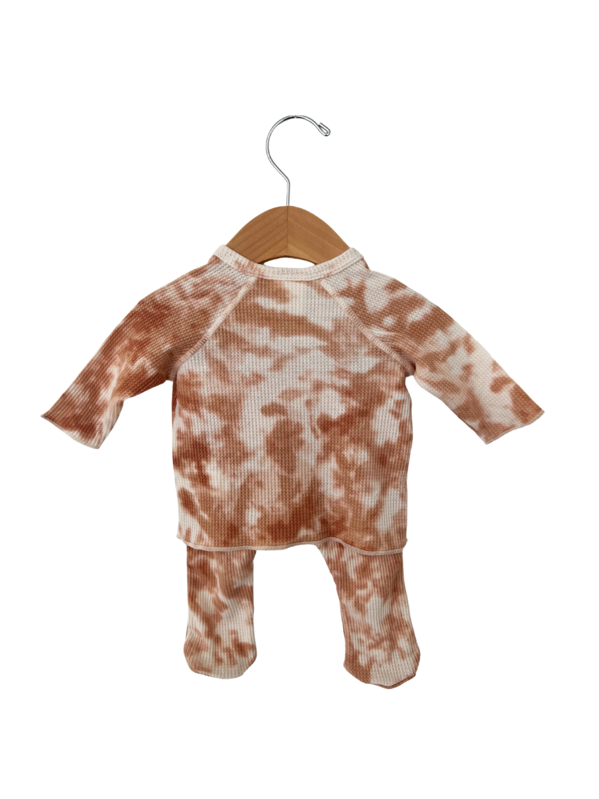 Brown tie-dye baby outfit hanging on a wooden hanger with a metal hook.