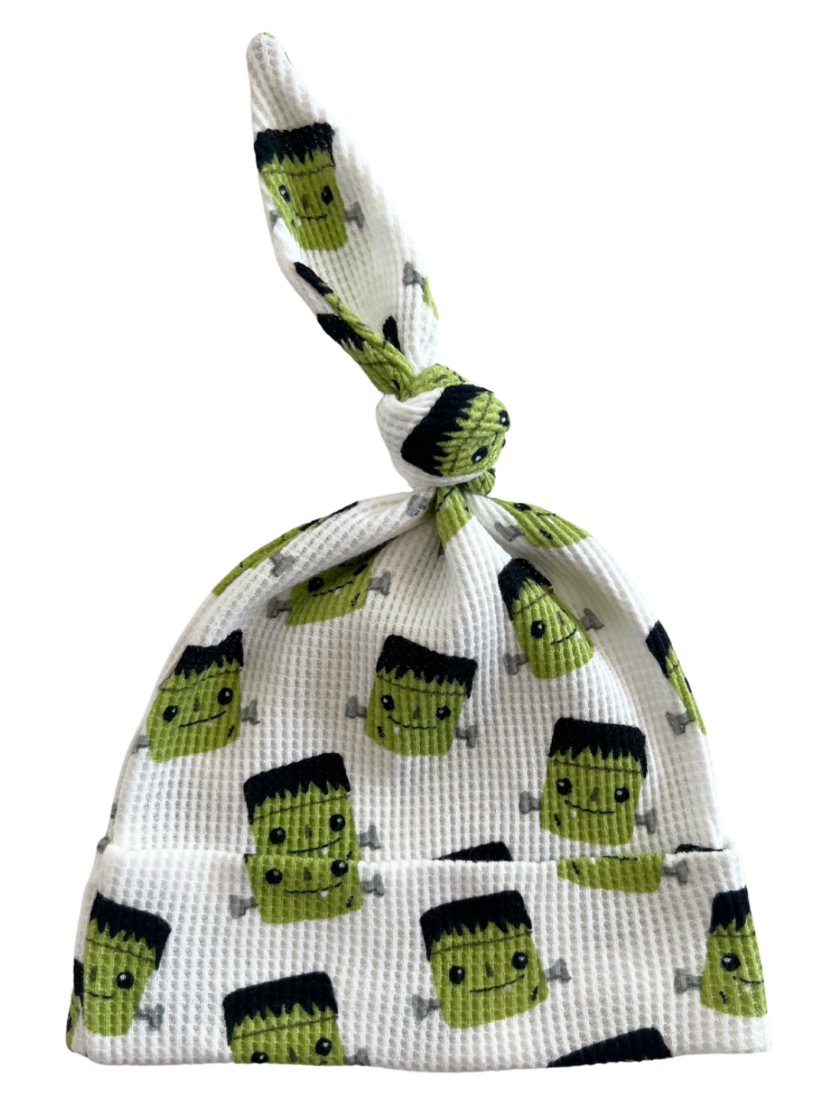 White baby hat featuring cute Frankenstein character patterns with a knotted top. Ideal for infants and playful occasions.