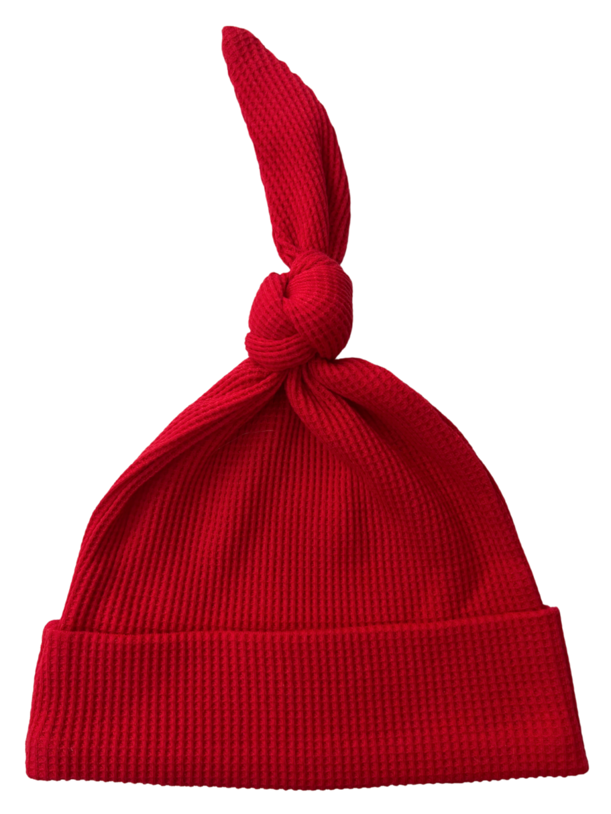 Red knit hat with a knot on top and a folded brim, designed for warmth and style.