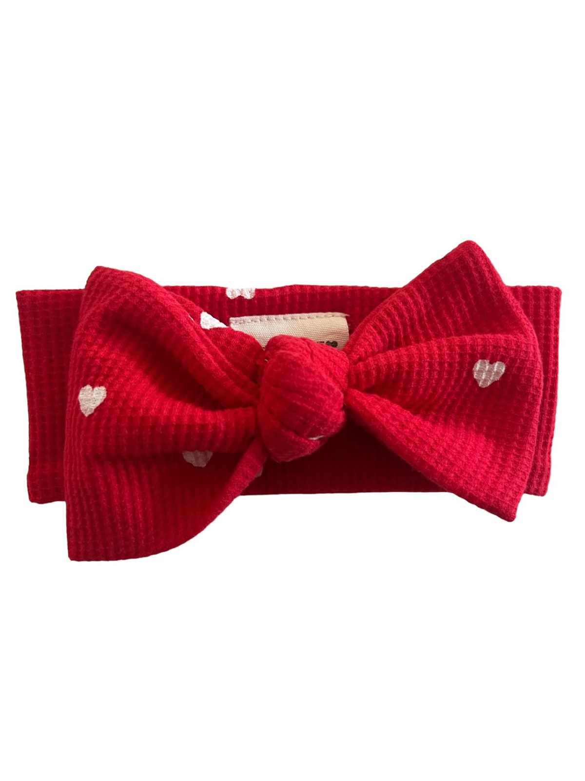 Red fabric headband with a large bow, featuring white heart patterns.