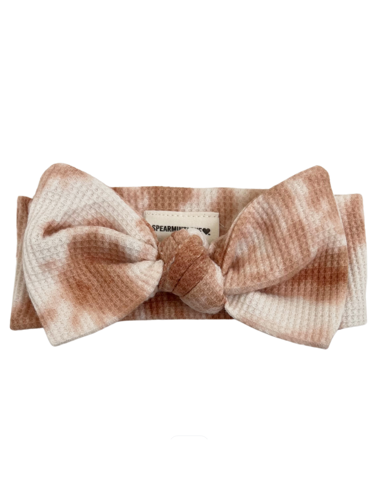 Light pink and cream tie-dye headband with a large bow and a label from SpearmintLOVE.
