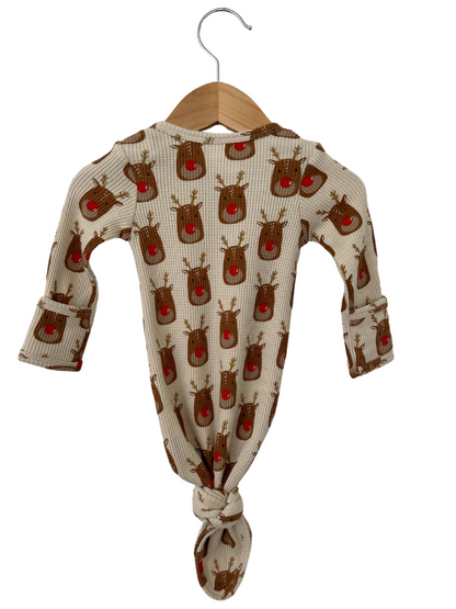 Baby romper with reindeer print, knotted hem, and hanging on a wooden hanger against a white background.