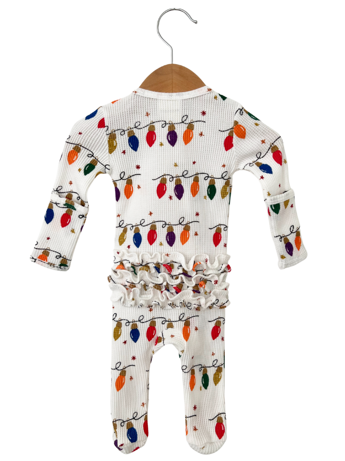 White baby onesie with colorful Christmas lights pattern, featuring ruffled waist and sleeves. Hanging on a wooden hanger.