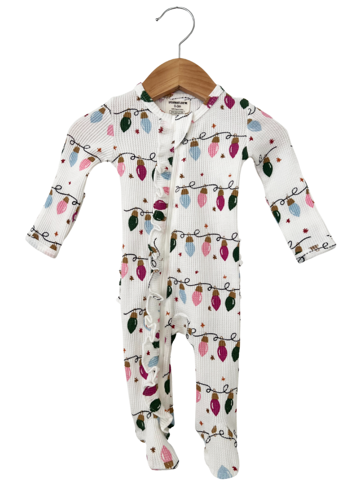 White baby onesie with festive light patterns, hanging on a wooden hanger.