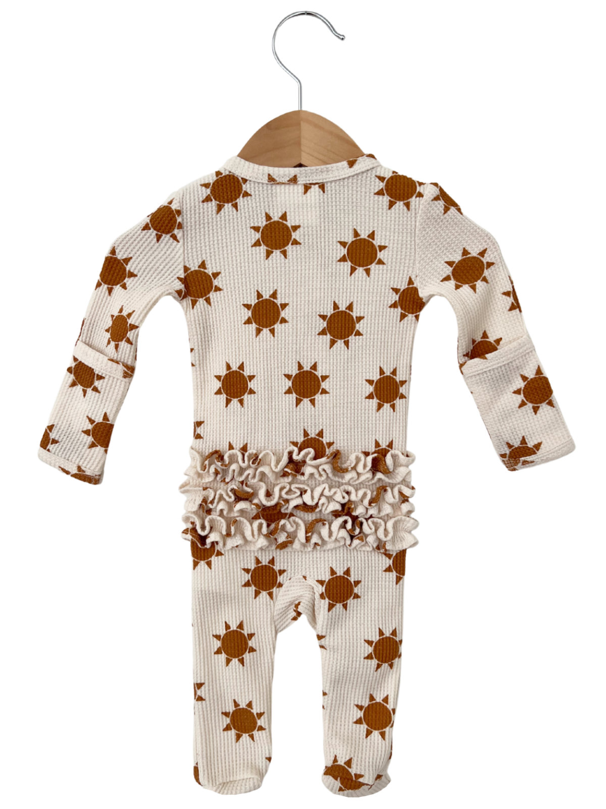 Baby onesie with orange sun pattern and ruffled trim, hanging on a wooden hanger against a white background.