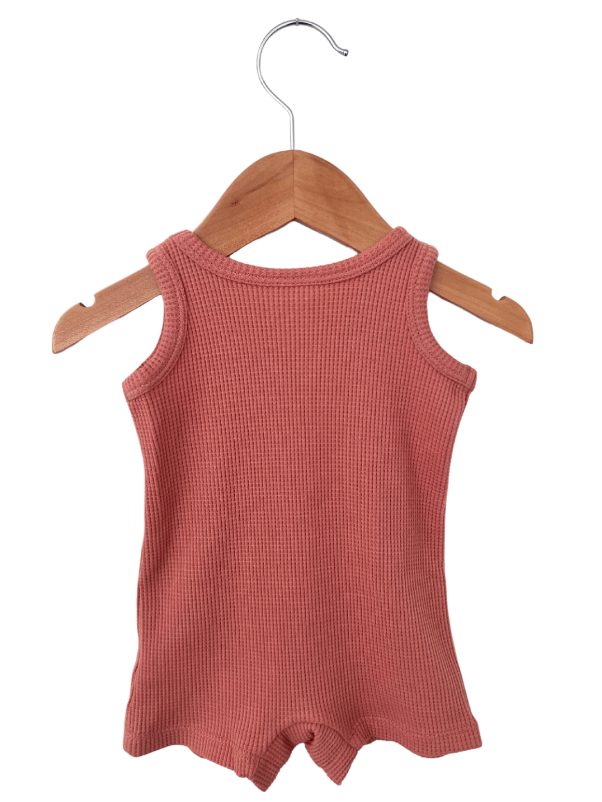 Pink ribbed baby romper hanging on a wooden hanger against a white background.