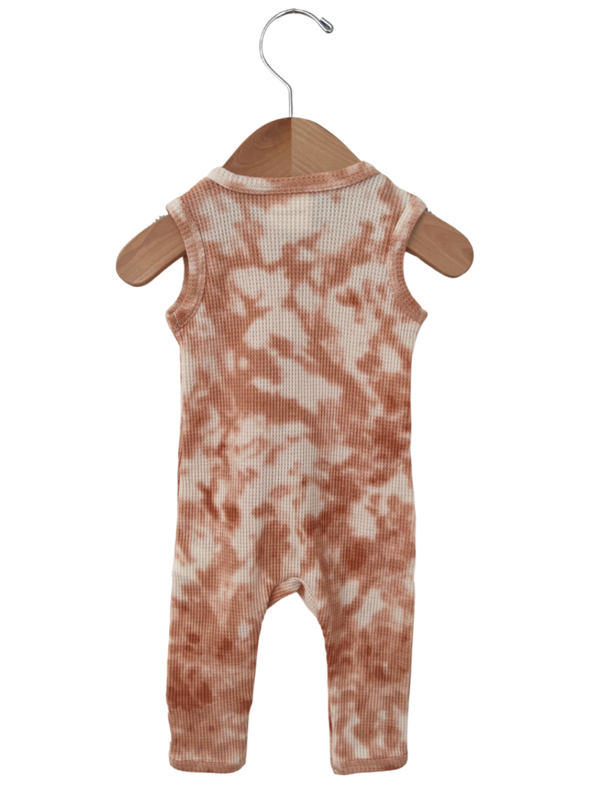 Peach tie-dye romper hanging on a wooden hanger against a white background.
