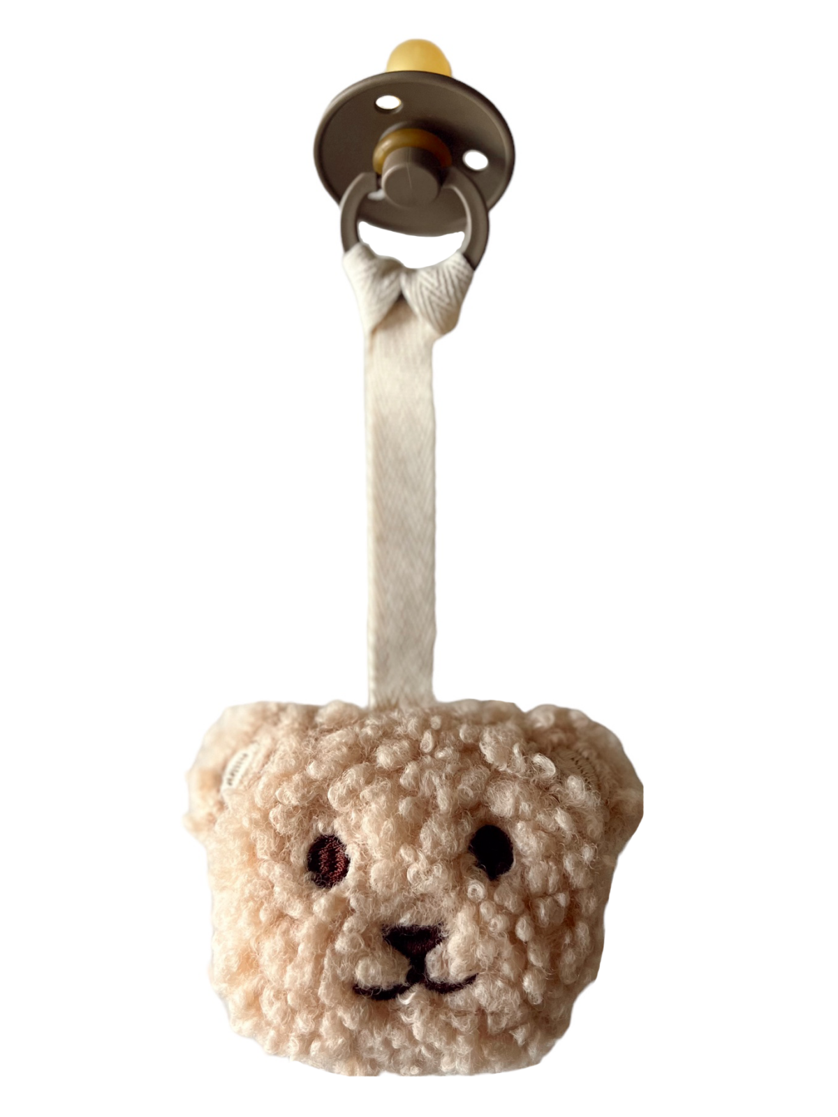 Soft teddy bear pacifier with a plush texture and a fabric strap, ideal for soothing infants.