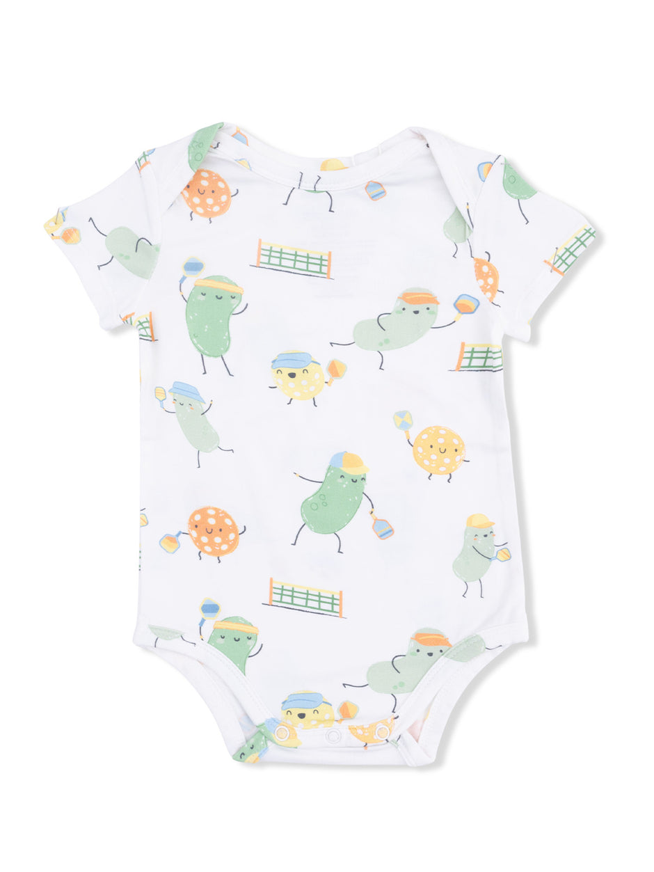 White baby onesie featuring playful, cartoonish fruits and vegetables engaged in sports.