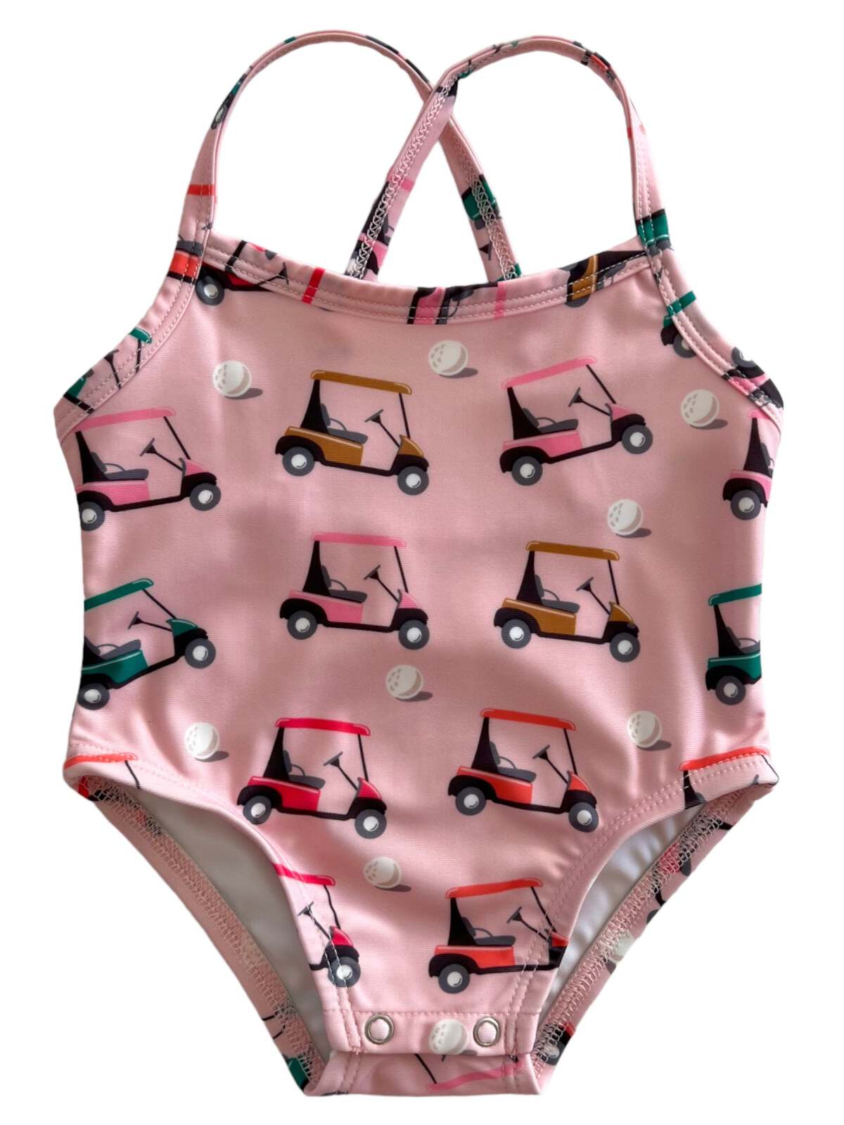 Pink swimsuit with golf cart pattern, featuring adjustable straps and snap closure. Ideal for summer activities.