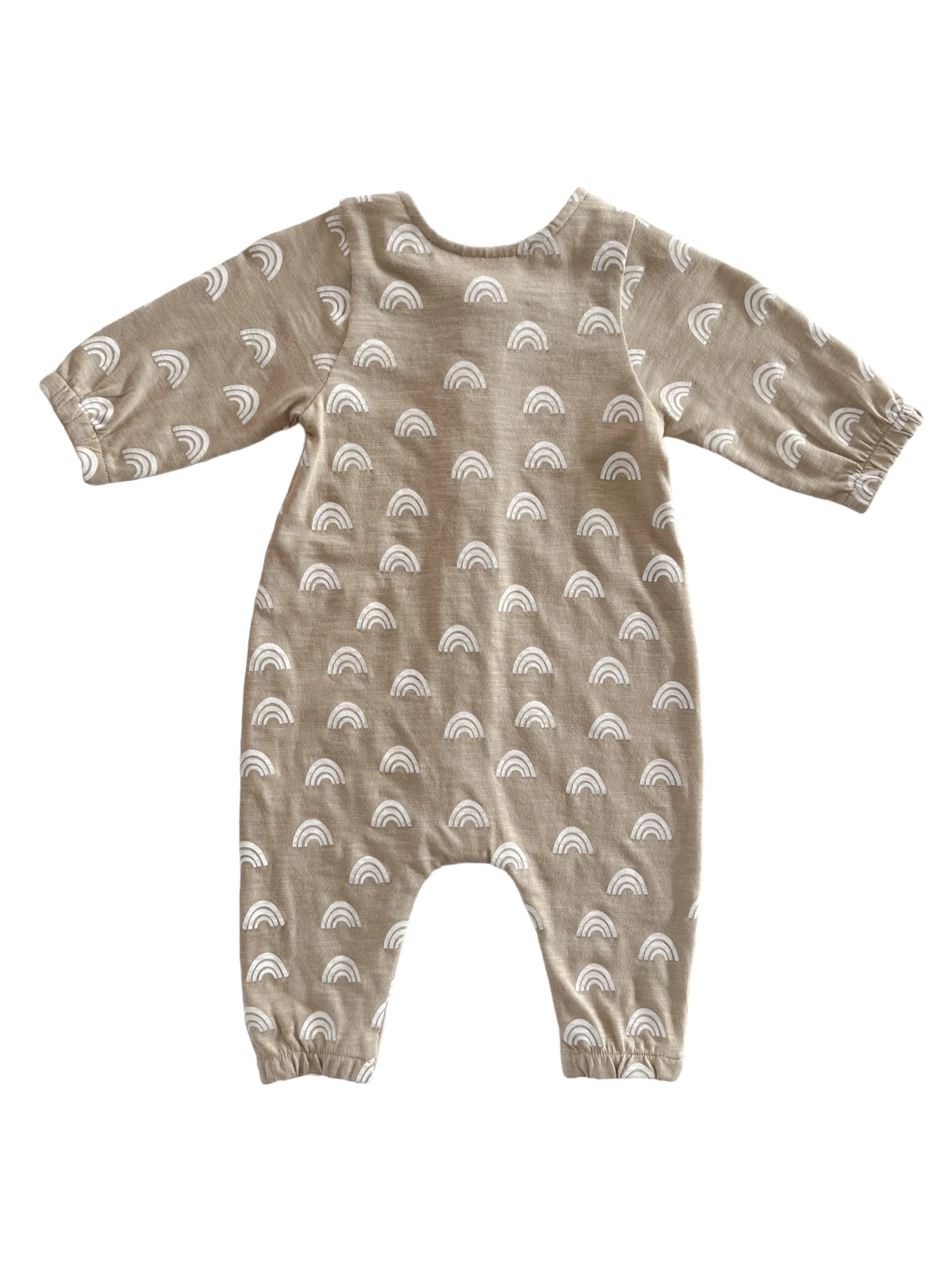 Beige toddler jumpsuit with white rainbow patterns, featuring long sleeves and an elasticized hem.
