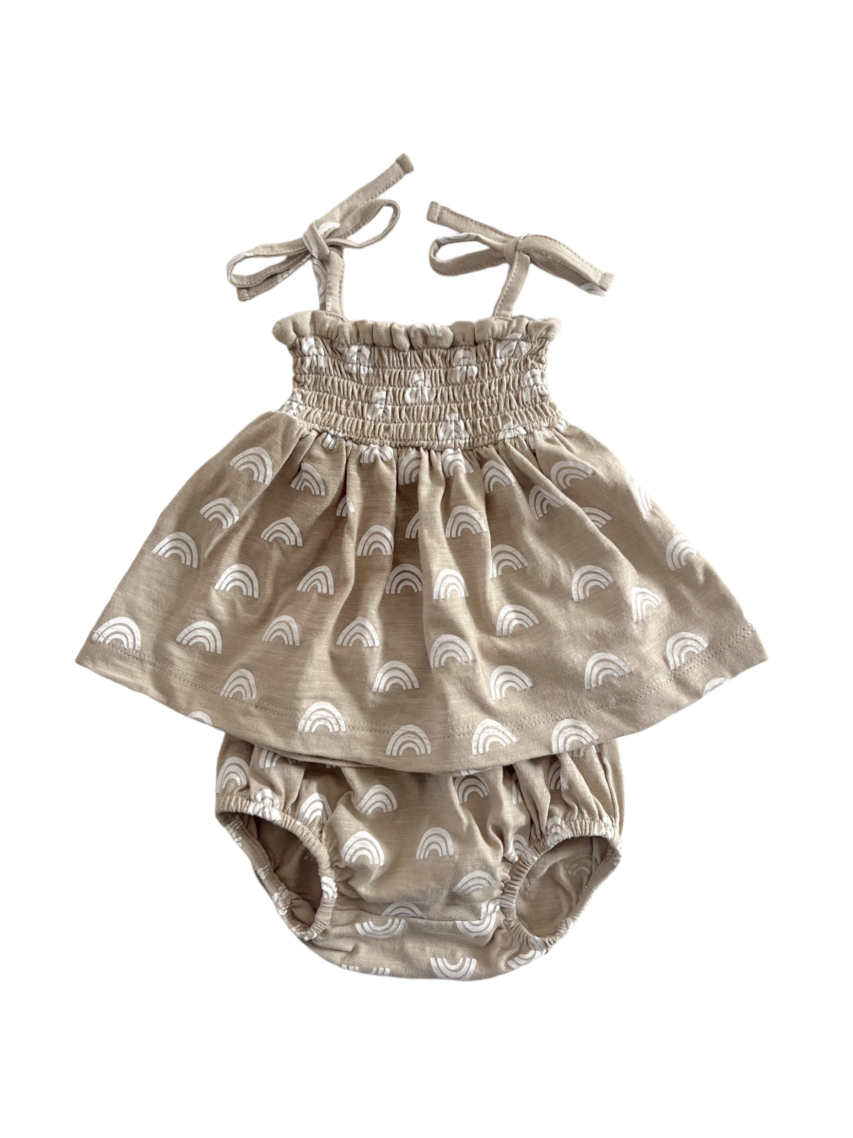 Light tan dress with white rainbow patterns and matching bloomers, featuring adjustable straps and smocked bodice.