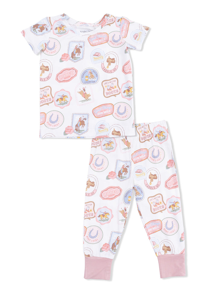 Children's pajama set featuring playful rodeo-themed prints in pastel colors. Short-sleeve top and long pants design.