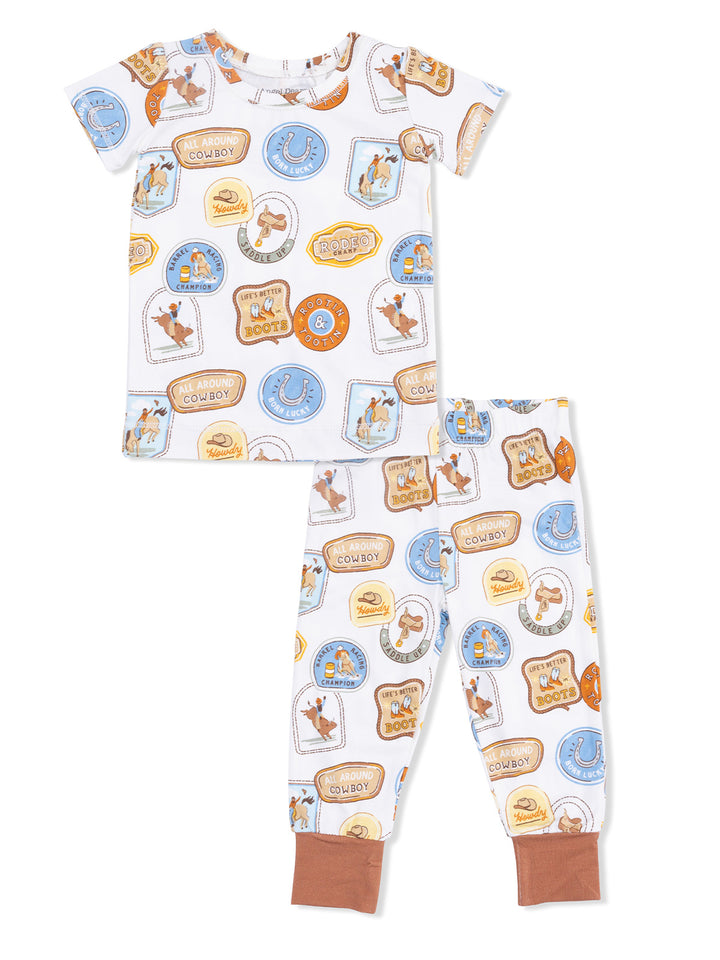 Children's pajama set featuring cowboy-themed graphics on a white background with matching pants.