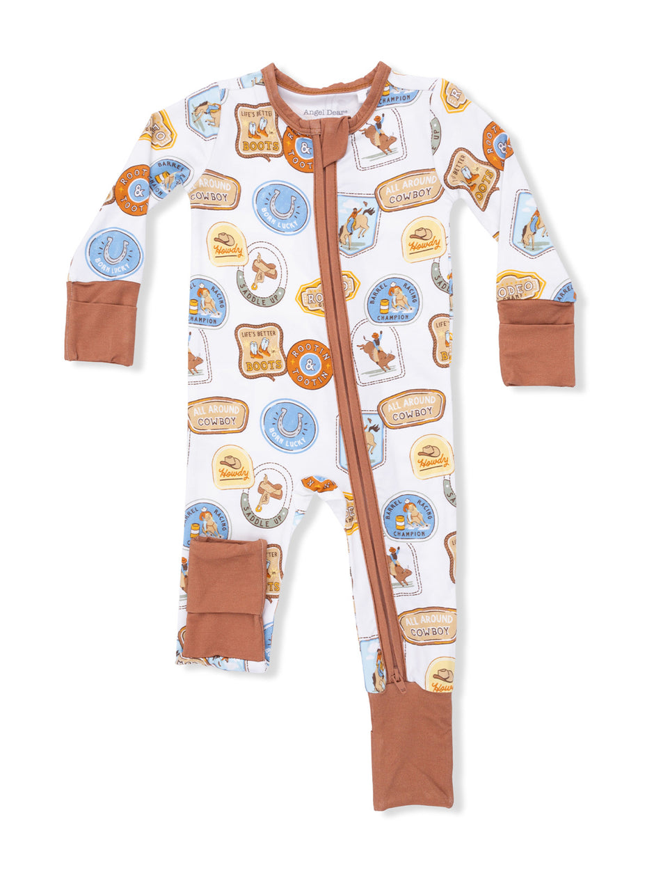 Cowboy-themed toddler pajamas featuring colorful badges and western designs, zip-up front and brown cuffs.