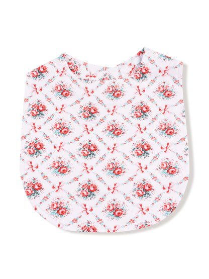 Floral-patterned fabric with red roses and ribbons on a white background, shaped like a top or bib.