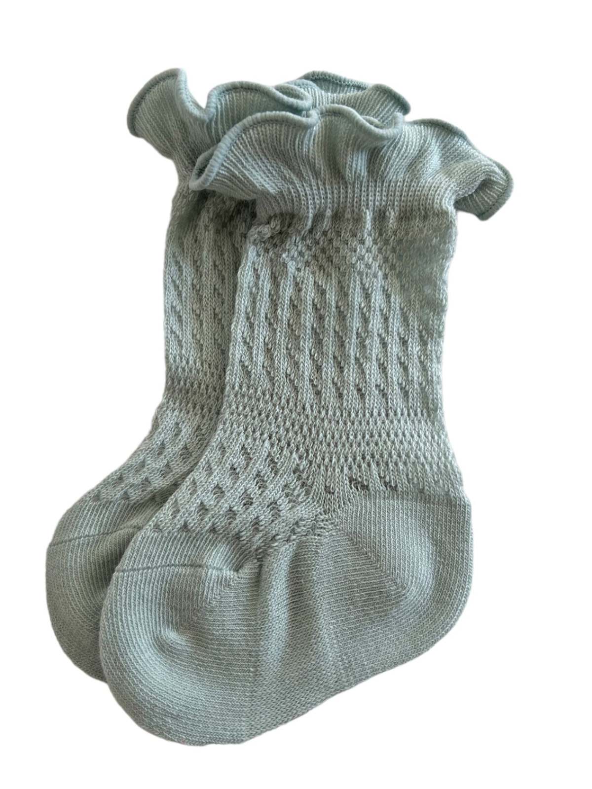 Light green knitted socks with a ruffled cuff and textured pattern. Ideal for stylish comfort.