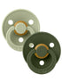 Two baby pacifiers in muted green tones with a gold accent, showcasing a modern design by BIBS.