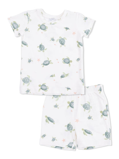 Children's pajama set featuring a turtle print on a white background, includes a short-sleeve shirt and shorts.