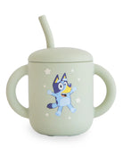 Light green sippy cup with a cartoon dog character and a straw, featuring star motifs.