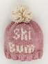 Knitted pink winter beanie with a pom-pom and "CHI WIT" text in white.