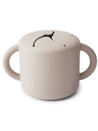 Light beige mug with two handles and a slit design on the top, ideal for ergonomic use.