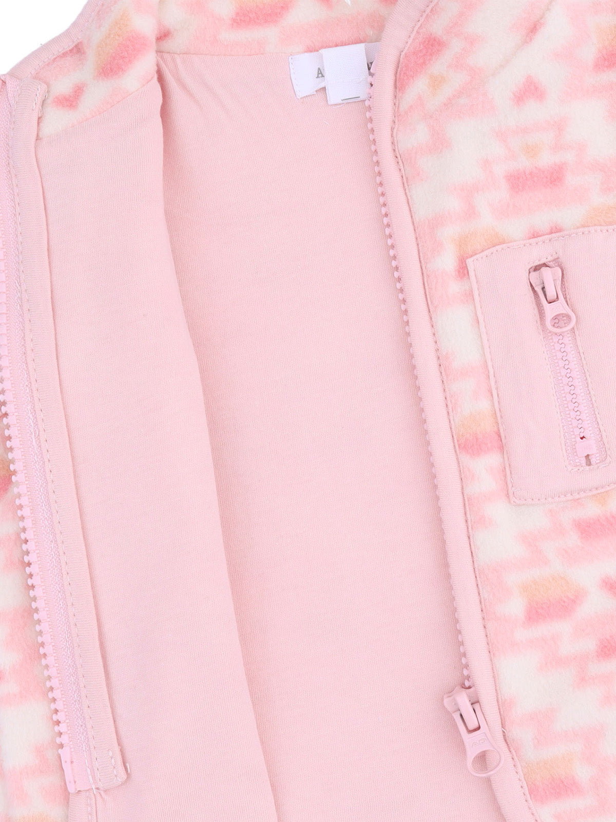 Light pink zip-up jacket interior with soft fabric and patterned lining. Features a small zip pocket.
