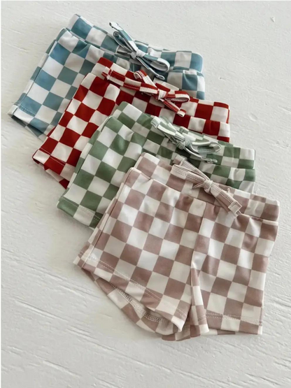 Colorful checkered shorts in blue, red, green, and brown arranged neatly on a white background.