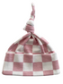 Pink and white checkered baby hat with a knot at the top, made from soft cotton fabric.
