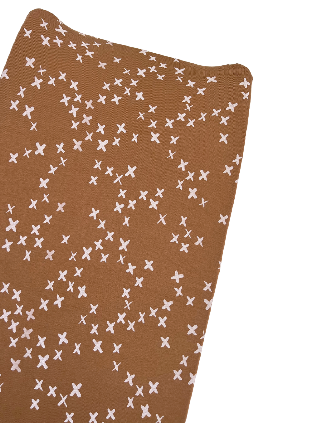 Brown fabric with scattered white 'X' shapes, creating a playful pattern and texture.