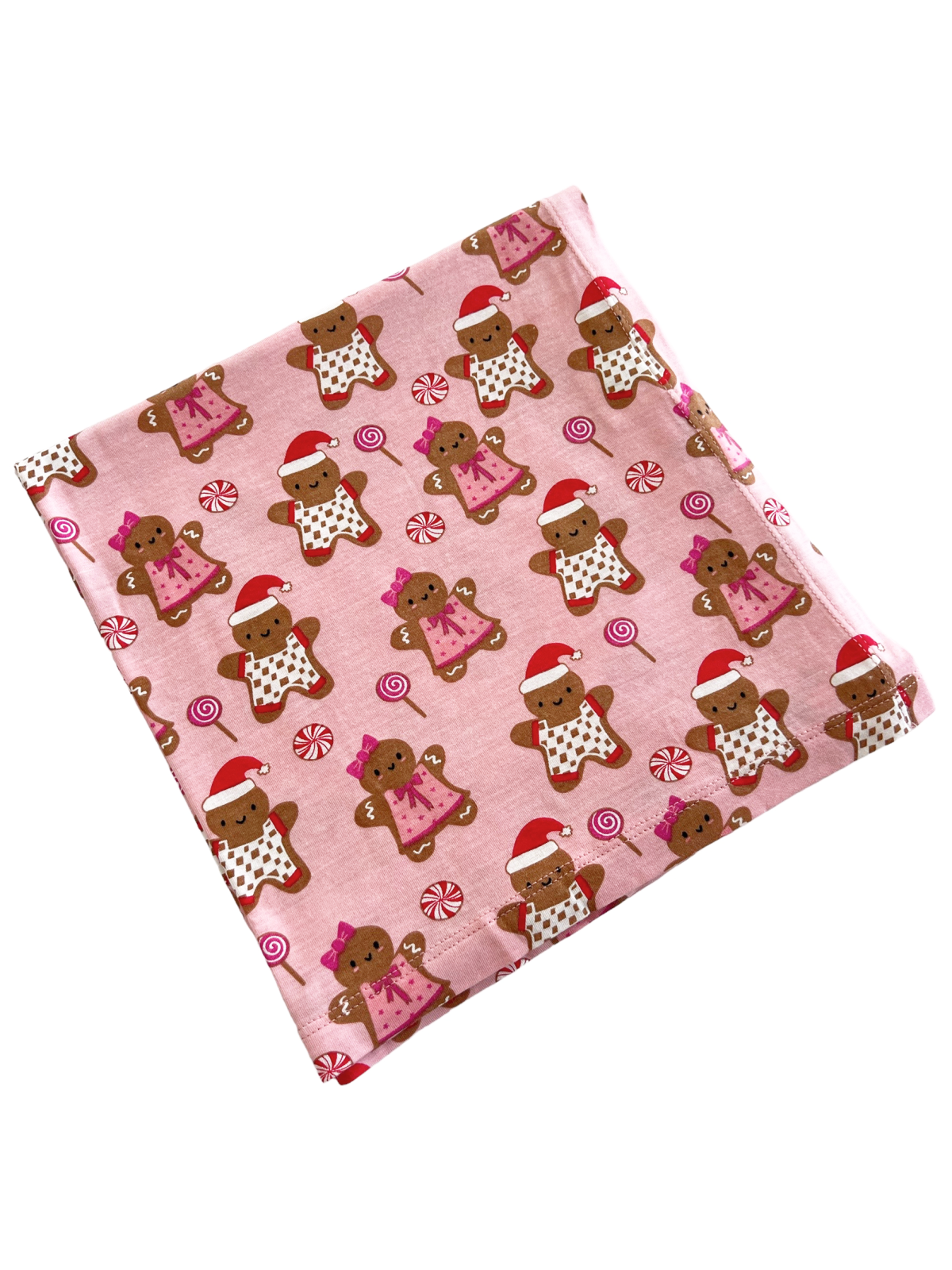 Pink fabric with gingerbread men and women in holiday attire, surrounded by candy patterns. Perfect for festive projects.