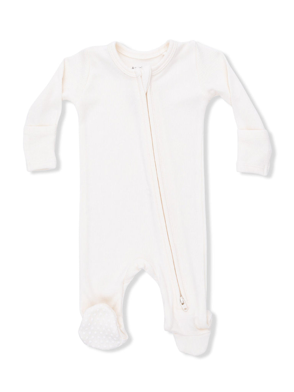 Cream-colored baby onesie with long sleeves and a front zipper, featuring textured feet for grip.