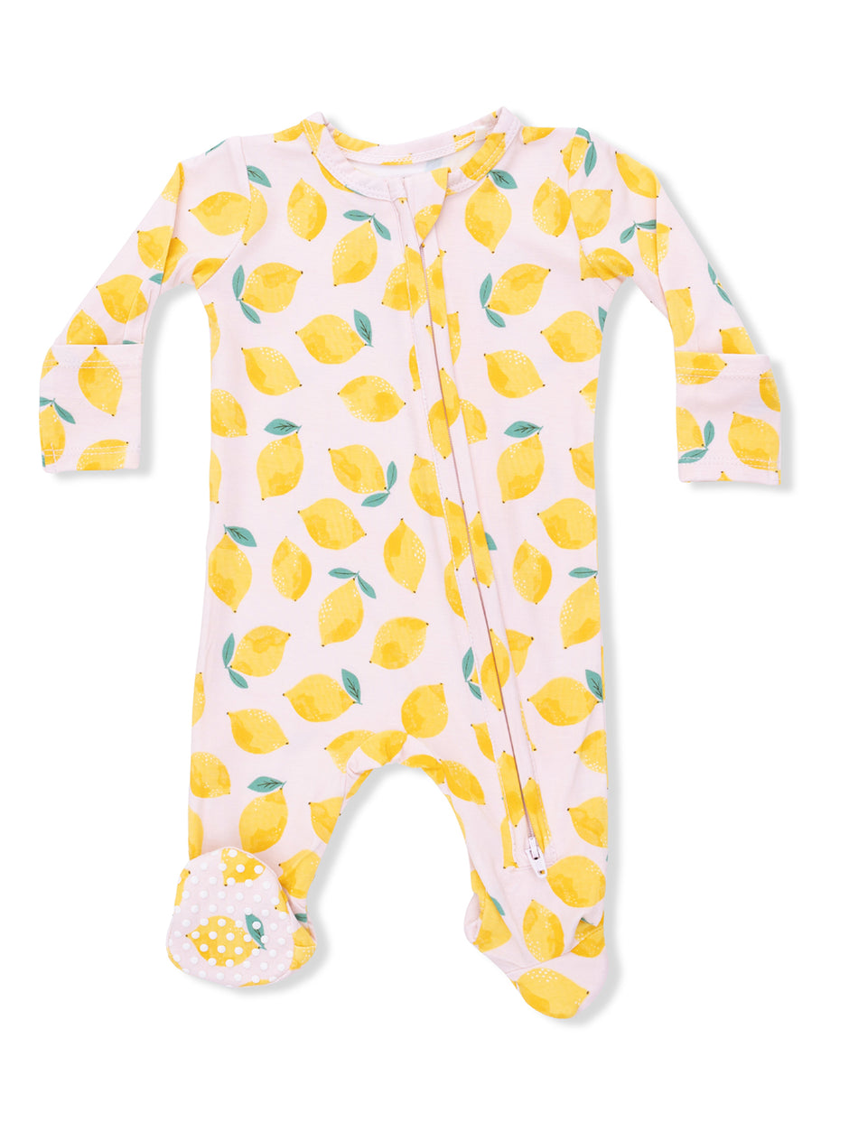 Pale pink onesie patterned with yellow lemons and green leaves, featuring footed design and zip closure.