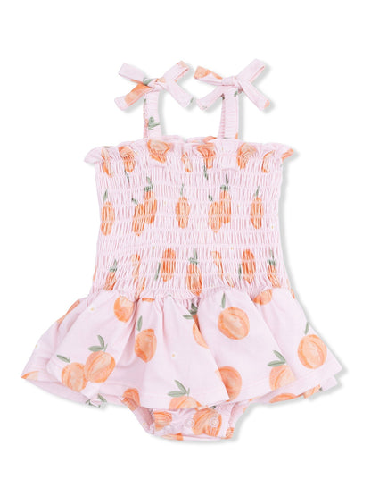 Pink baby romper with orange fruit print, smocked top, and ruffled skirt. Features shoulder bows.